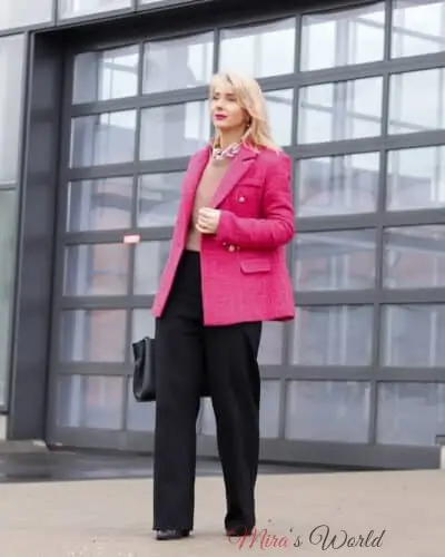 Frau in rosa Jacke und schwarzer Hose.