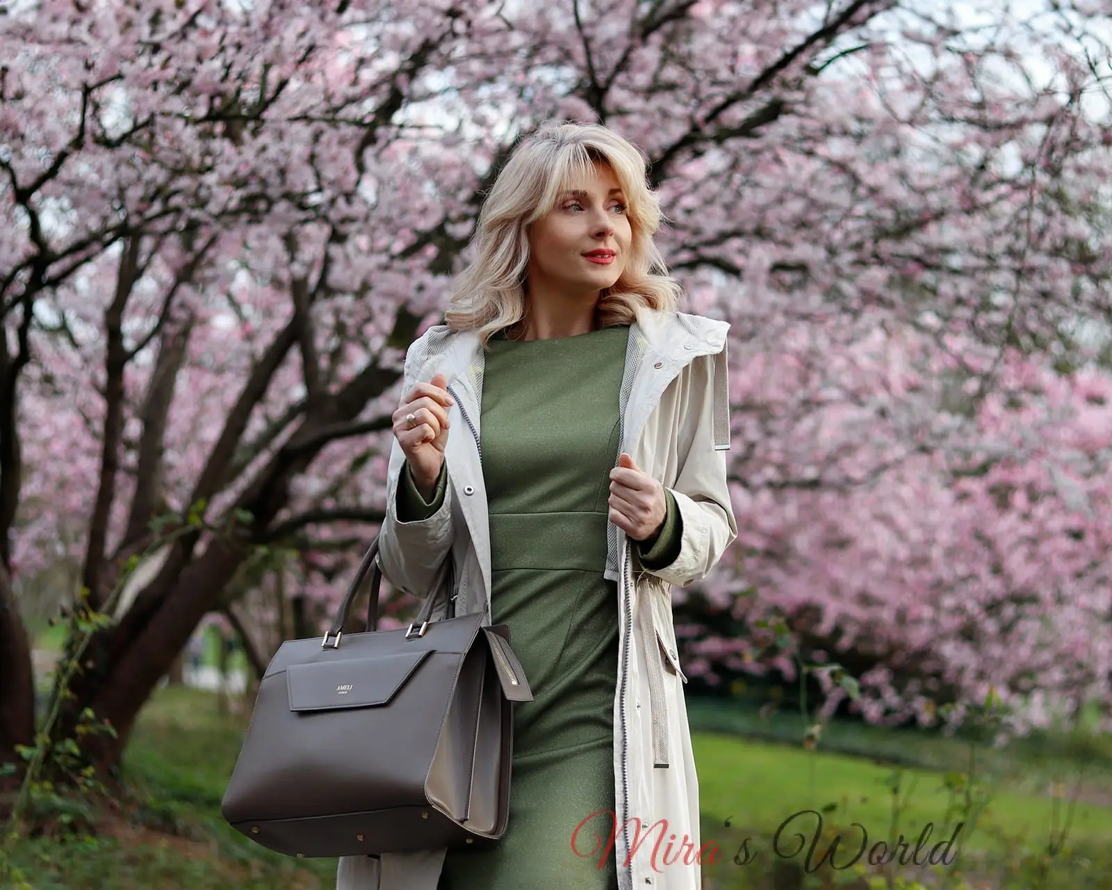 Woman with bag and pink blossoms.